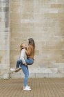 Mujeres abrazando y riendo - foto de stock