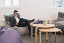 Thoughtful man sitting at beanbag in office — Stock Photo
