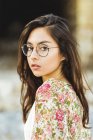Дівчина в окулярах дивиться через плече — стокове фото