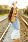 Chica en denim posando sobre ferrocarril - foto de stock