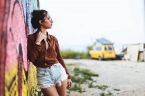 Girl with leaning on graffiti wall — Stock Photo