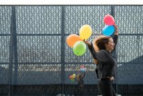 Mujer corriendo con globos - foto de stock