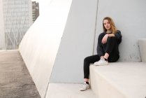 Donna seduta su blocco di cemento — Foto stock