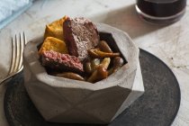 Bife de lombo com cogumelos e batatas fritas em tigela de pedra — Fotografia de Stock