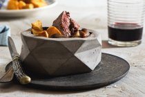 Tenderloin steak with mushrooms and potato fries in stone bowl — Stock Photo