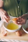 Mujer separando yema de huevo - foto de stock