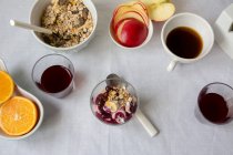 Vista piatta di yogurt con marmellata e muesli con tazze di caffè e frutta — Foto stock