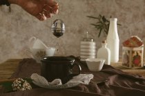 Mani che tengono setaccio tè sotto la tazza — Foto stock