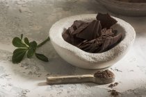 Nature morte de bol en pierre avec chocolat noir — Photo de stock