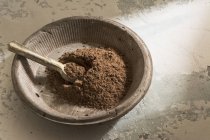 Bol en pierre avec poudre de cacao noir et cuillère en bois — Photo de stock