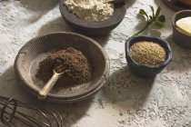 Stillleben bäuerlicher Schalen mit Kakao, Mehl und Sesam — Stockfoto