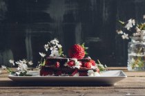 Natureza morta de torta de morango caseira e galhos floridos na mesa rural — Fotografia de Stock