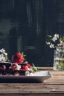 Natureza morta de torta de morango caseira e galhos floridos na mesa de madeira — Fotografia de Stock