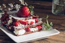 Hausgemachter Erdbeerteer mit Sahne auf Teller mit blühenden Zweigen — Stockfoto
