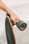 Hand hält Skateboard — Stockfoto