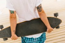 Чоловік тримає скейтборд — стокове фото