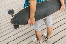 Fechar de homem segurando longboard — Fotografia de Stock