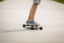 Gambe di persona a cavallo skateboard — Foto stock