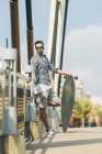 Uomo in piedi con skateboard — Foto stock