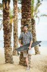 Homem em vestuário de verão com longboard — Fotografia de Stock