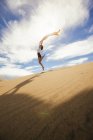 Femme dans le moment de sauter dans le désert — Photo de stock