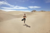 Mulher esticando as pernas no deserto — Fotografia de Stock