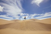 Женщина практикует йогу на песках — стоковое фото
