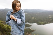 Young woman feeling cold on cliff — Stock Photo