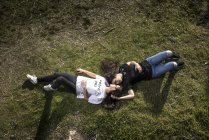 Lesbian couple lying on lawn — Stock Photo