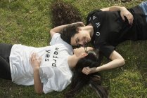 Lesbian couple lying on lawn — Stock Photo