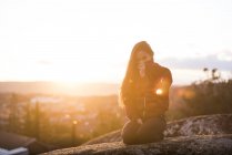 Girl sitting on edge of hill — Stock Photo
