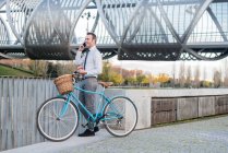 Business man standing by bicycle — Stock Photo