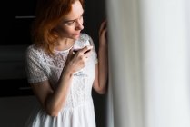 Mujer bebiendo vino en la ventana - foto de stock