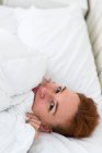 Fröhliche Frau im Bett — Stockfoto