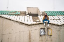 Young cute girl in abandoned stadium — Stock Photo