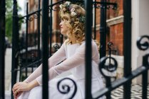 Gorgeous woman on steps in white dress — Stock Photo