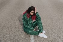 Depresssed girl sitting on road — Stock Photo