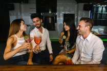 Amigos tomando cócteles en el bar - foto de stock