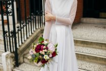 Donna con fiori in abito bianco — Foto stock