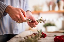 Unbekannte Frau schneidet Blumen in Werkstatt — Stockfoto