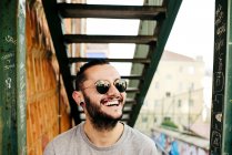 Sorrindo hipster homem no fundo urbano — Fotografia de Stock