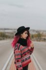 Девушка в шляпе позирует на городской дороге — стоковое фото