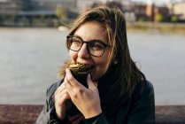 Frau beißt in Cupcake — Stockfoto