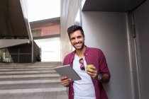 Cheerful man with apple and tablet — Stock Photo