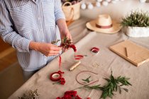 Crop person making headdress with flowers — Stock Photo