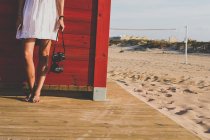 Femme tenant une caméra à la plage — Photo de stock