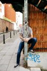 Mann posiert hinter Metallstange — Stockfoto