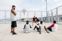 Homens assistindo outros jogando basquete — Fotografia de Stock