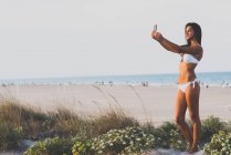Femme en bikini prenant selfie — Photo de stock