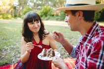 Erwachsenes Paar beim Kuchen auf dem Rasen — Stockfoto